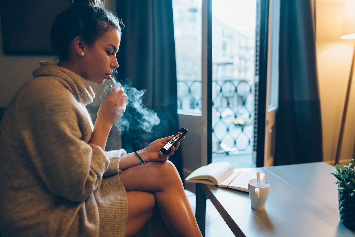 girl sitting at home vaping looking at her phone cbd oil fatty acid binding proteins medical cannabis sativa novel anti inflammatory drugs inflammatory cells cbd oil cannabis plant cannabinoid receptors cannabidiol cbd potency cbd oil medical marijuana