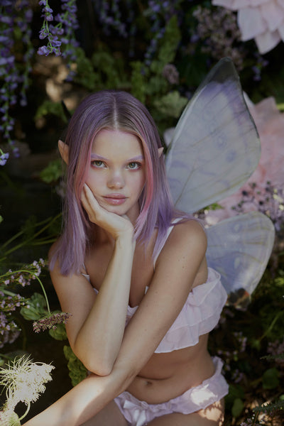 A fairy in the forest wearing the Midsummer Lilac Floating Wings
