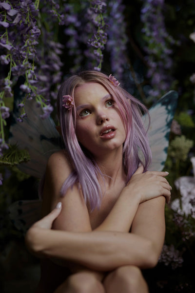 A fairy in the forest wearing the Rosewater Pink Floating Butterfly wings