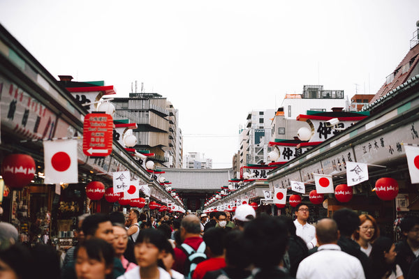 Crowd of people walking along a flag-lined street in Japan