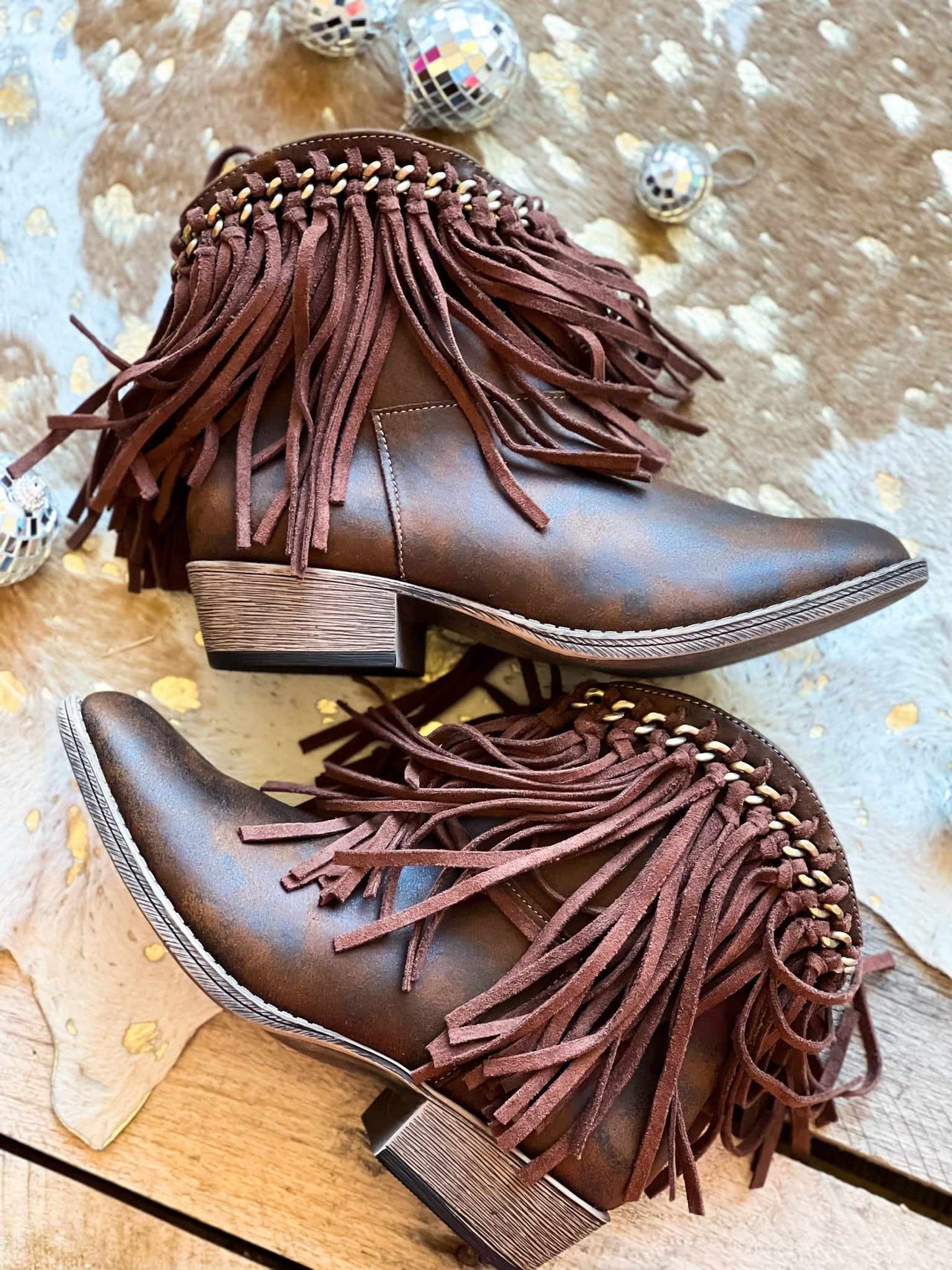 Brown leather western booties with fringe.