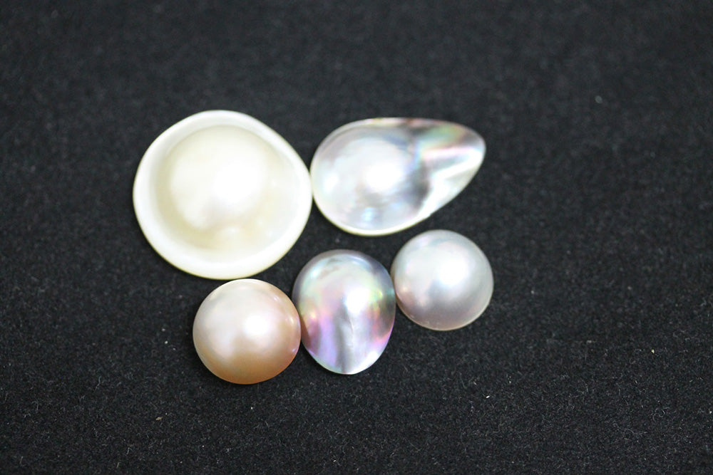 Sample of mabé pearls under regular light; the bottom center is a Sea of Cortez pearl
