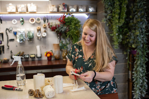 Owner of North Wood Blooms cuts sheets of sola wood into individual petals to create a handmade sola wood flower in the NWB wood flower design studio