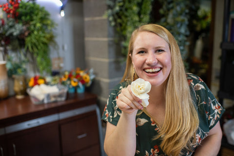 andi gretzinger owner of north wood blooms llc holding a handmade wood flower