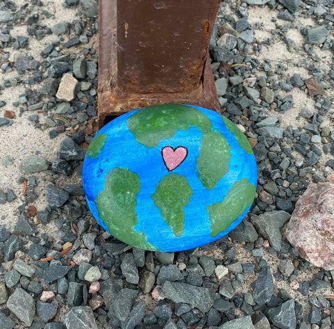 The earth painted on a rock, along with a heart, as a reminder it's Earth Day