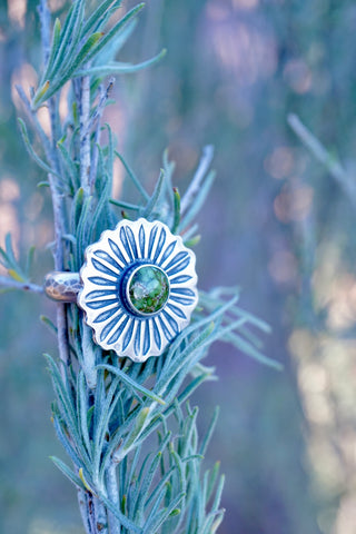 image of a silver ring  in the shape of a flower with a turquoise stone in the middle