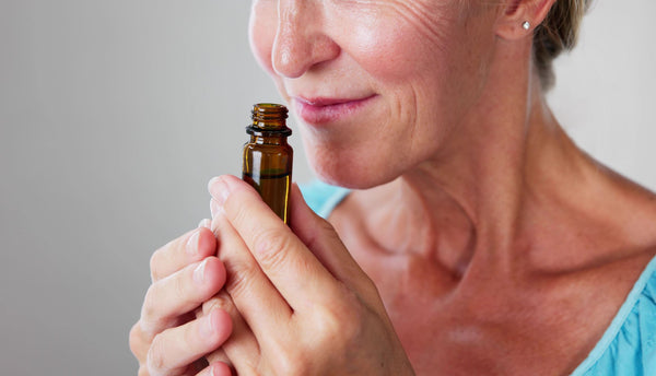 Woman smelling and essential oil bottle