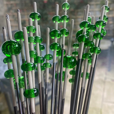A large bunch of mandrels with multiple green jameson beads beads on each one