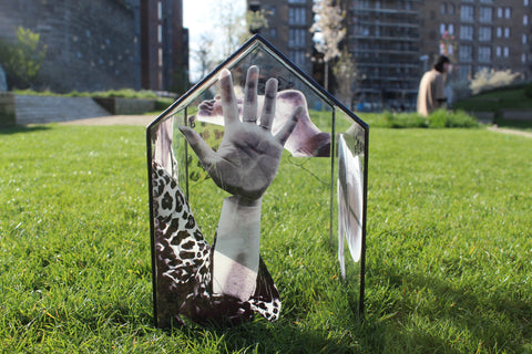 Imagery of a hand on a clear glass house