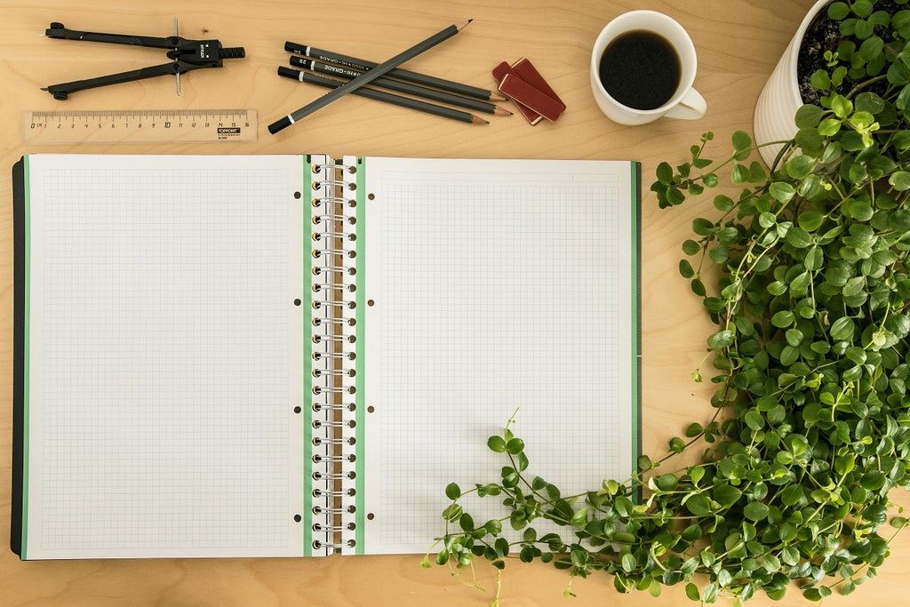 White notebook with pencils on a table