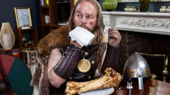 viking eating a piece of meat with bone inside a modern urban room