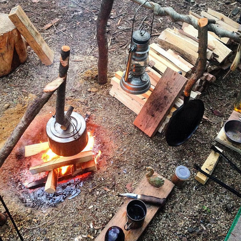 bushcraft and survivalist camp with fire and cooking equipment