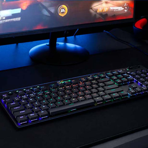 Teclado negro conn luces LED para gamer. En el fondo se observa una parte de una computaodora