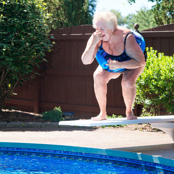 A woman holding her nose preparing to jump into a swimming pool