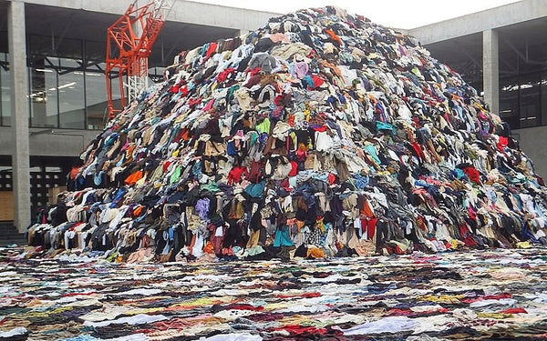 A huge pile of discarded clothing in a warehouse courtyard