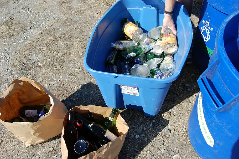 Man recycling plastic and glass bottles