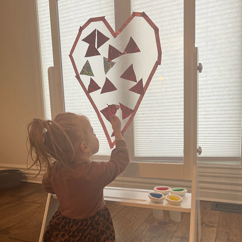 Step 2: Cut out large, heart-shaped piece of self adhesive contact paper (sticky side up) and tape with masking tape or artist tape to Peek-A-Boo Artist Easel or window.