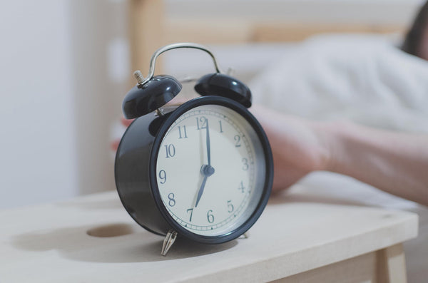 hand reaching for alarm clock