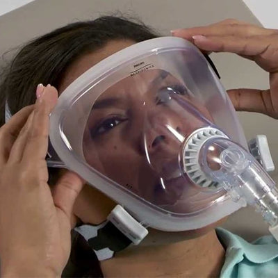 woman adjusting CPAP mask