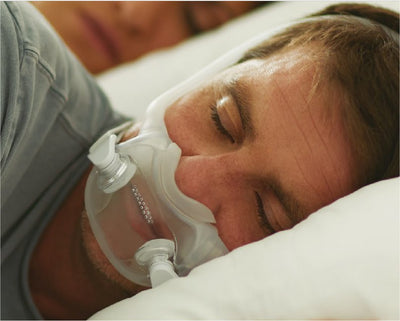 man sleeping with CPAP mask