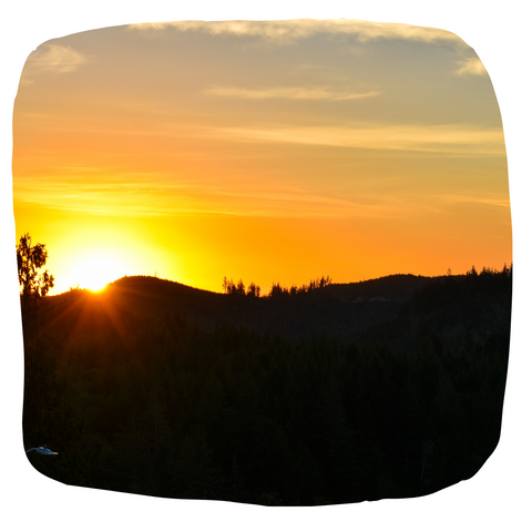 A beautiful orange sunrise over a dark wooded hill