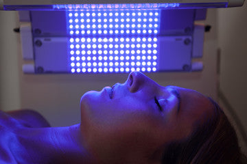 woman getting blue light therapy on her face