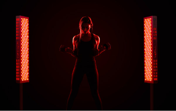 Woman in Active Wear Standing Next to Red Light Therapy Devices