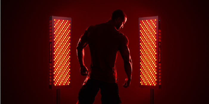 Body Builder Standing Next to Red Light Therapy Device