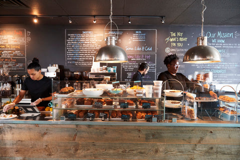 Busy cafe front counter with cakes