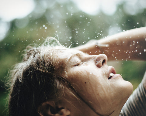 Woman in summer showering outside