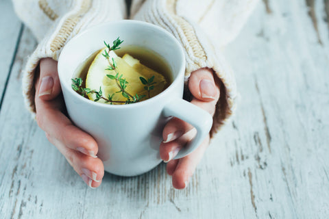 Lemon and herbal tea in a white mug