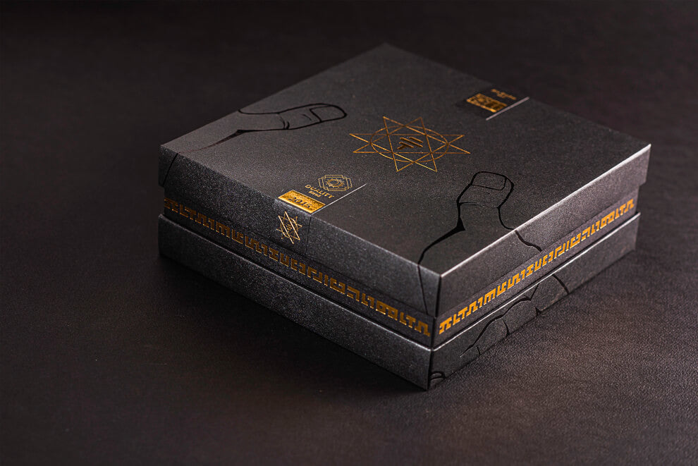 A black box with gold lining (To'ak's Master Series) sits on a black surface