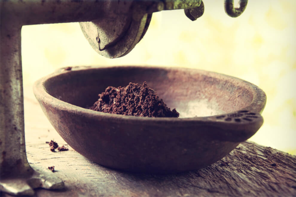 obrázek kamenného mlýnku obsahujícího kakao, které bylo rozemleto na pastu