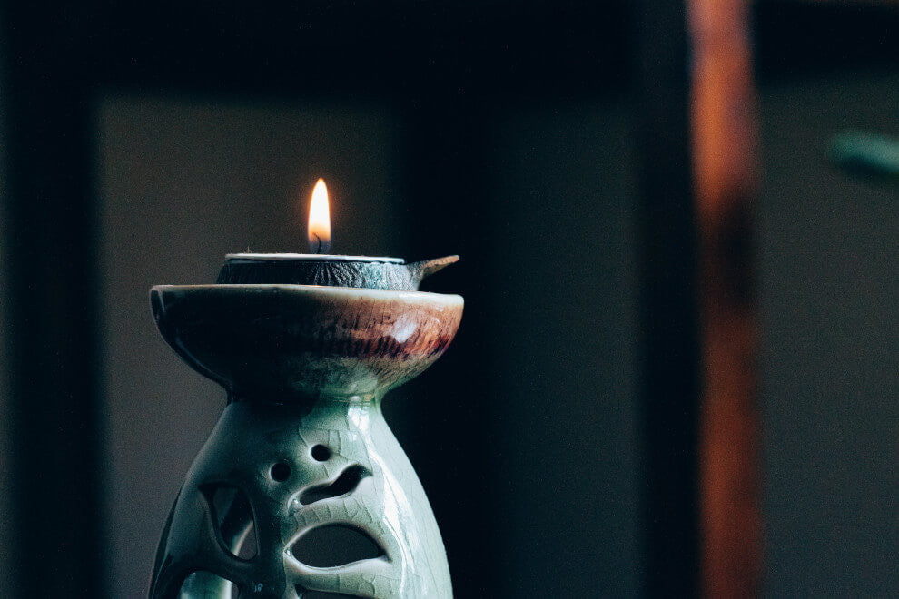 a small lit candle sits atop a blue candle holder