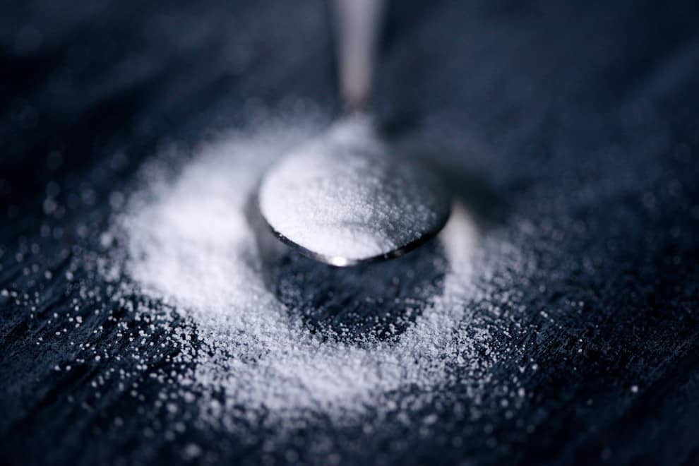 a teaspoon filled with white sugar
