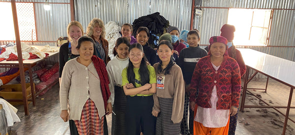 A group of smiling women workers with Mexicali owners Kim & Carly Erskine at a Mexicali maker space cotton production site in Kathmandy, Nepal