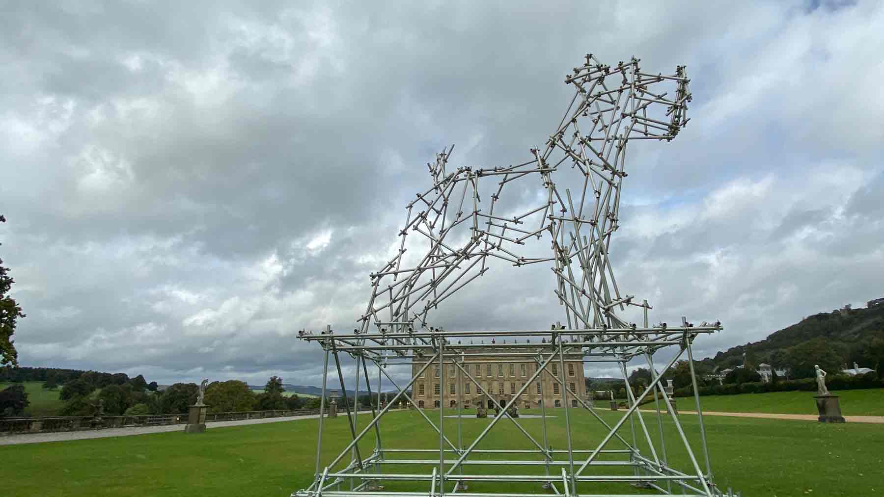 Chatsworth seen through a large dog sculpture made from scaffolding