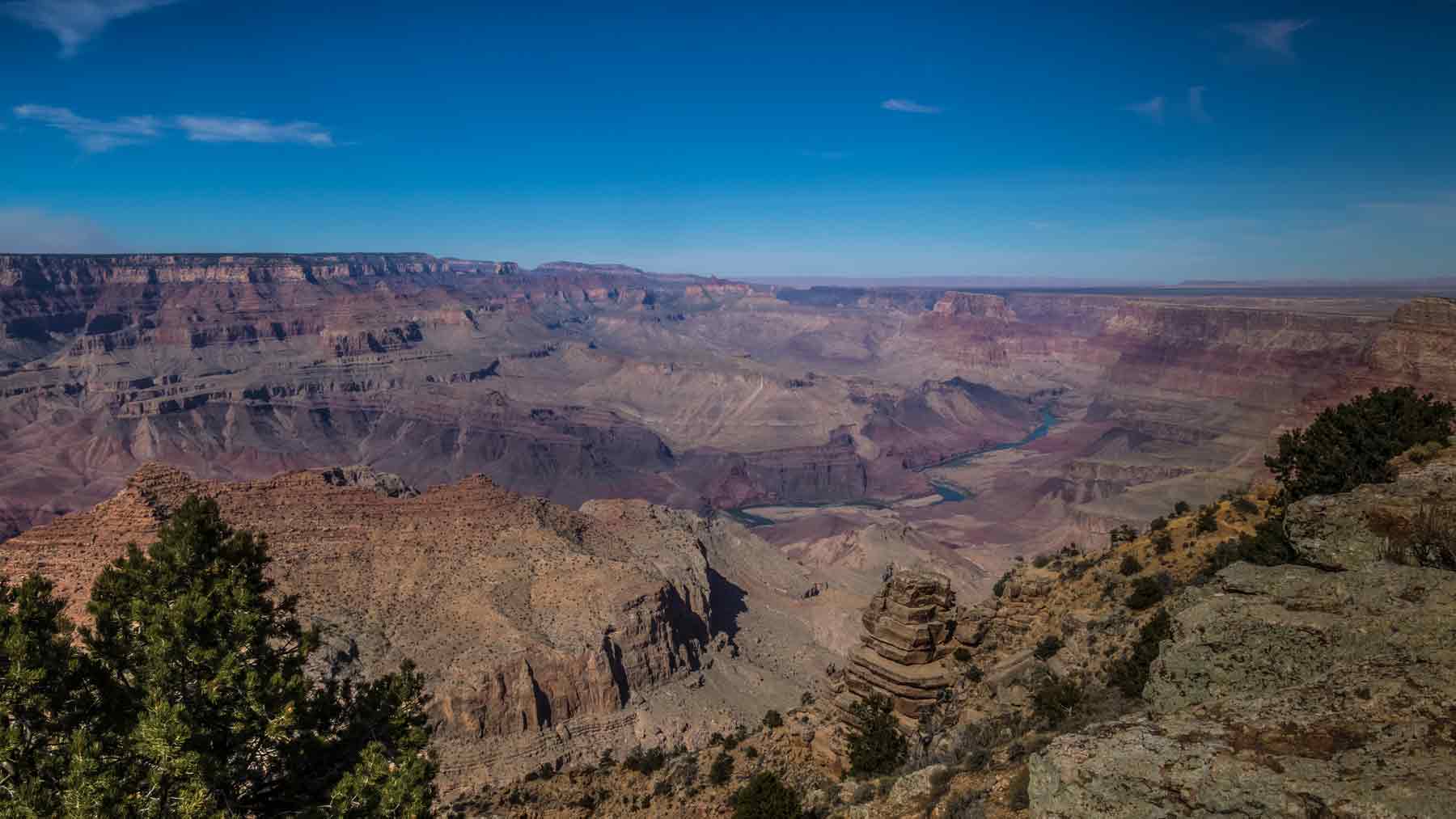 Bright blue sky over the Grand Canyon with the Colorado River visible below