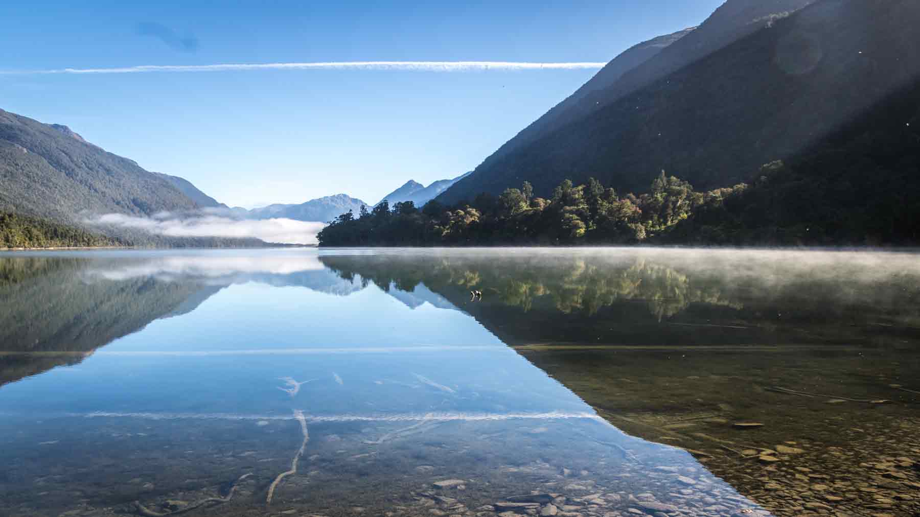 The hills and sky reflected on the glasslike surface of Lake Alabaster, Fiordland, New Zealand. Taken by Asmuss founder Fiona