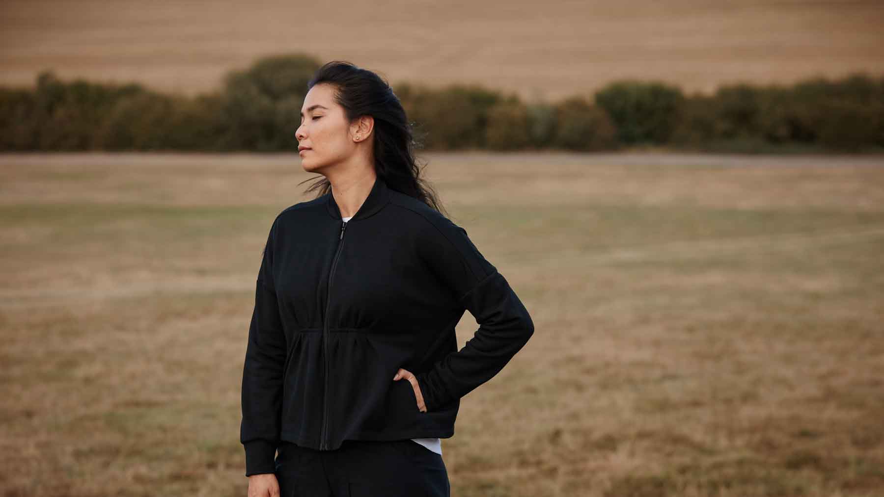 Woman wearing the Asmuss Zip Through Sweat featuring our responsibly sourced trims