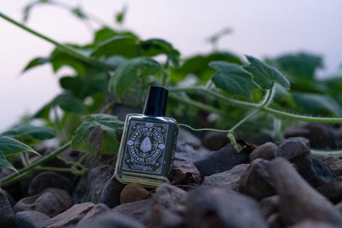 cologne oil fragrance sitting on rocks near river