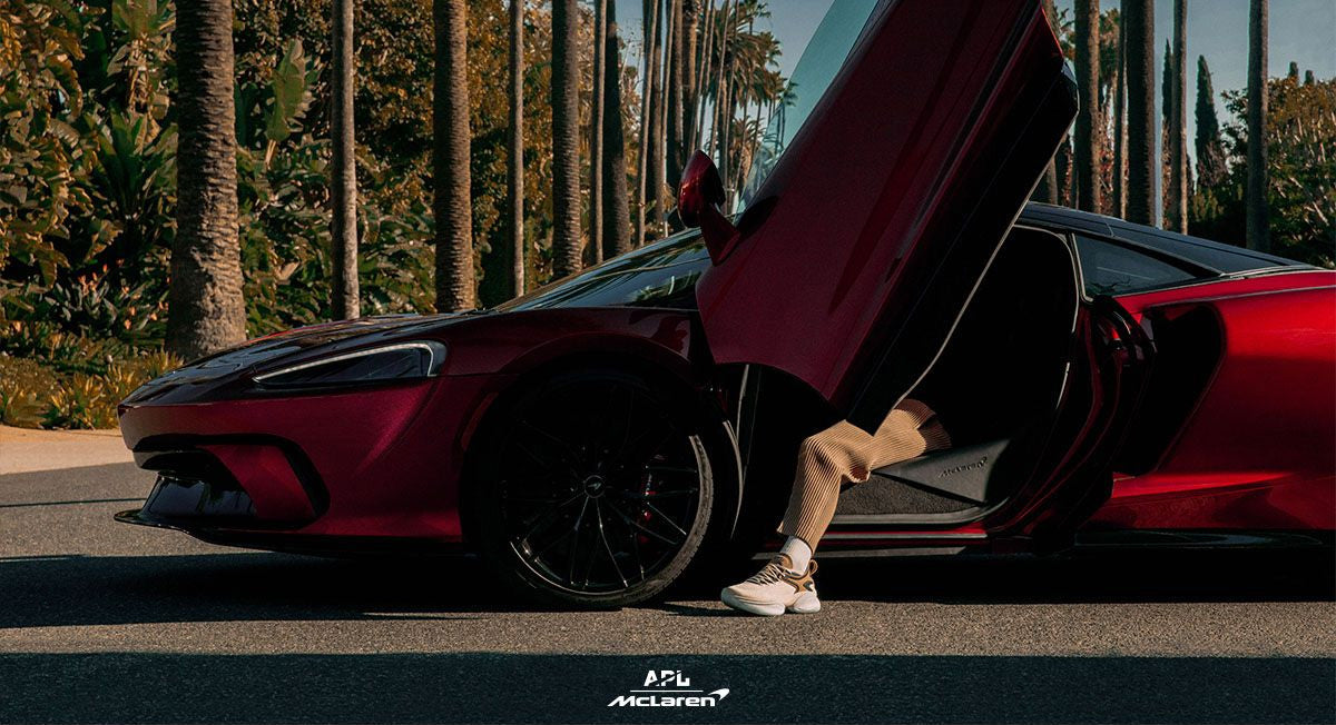 Photo of someone wearing APL McLaren HySpeed shoes while sitting in a McLaren car