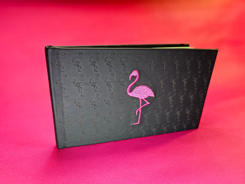 Hot pink background with a pilot logbook wrapped in black leather
