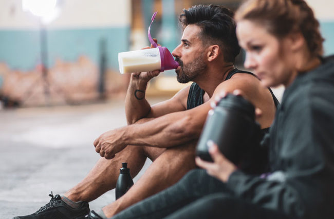 man and woman drinking pre workout