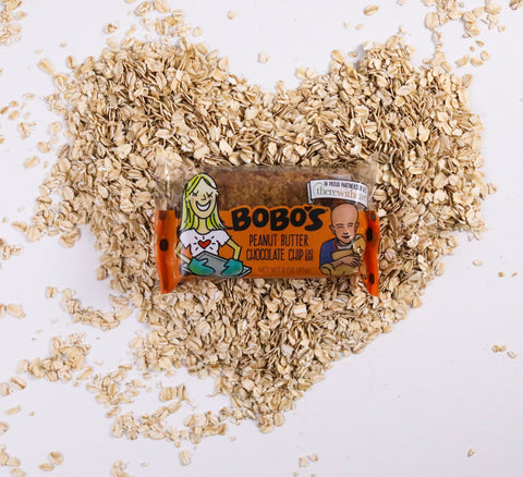 A Bobo's Oat Bar on a bed of oats shaped like a heart 