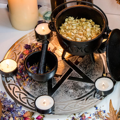 Image of cast iron cauldron and mortar and pestle on a pentagram aluminium tealight holder.
