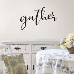 The word, "gather" on the wall behind a dining room table.