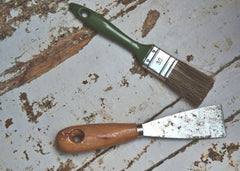 Clean brush and metal scraper laying on floor