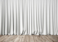 White curtains that reach a wooden floor.