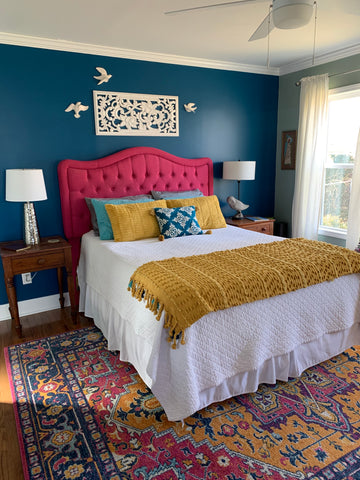 Bedroom with navy accent wall white lattice wall art, fusia headboard and mustard accents